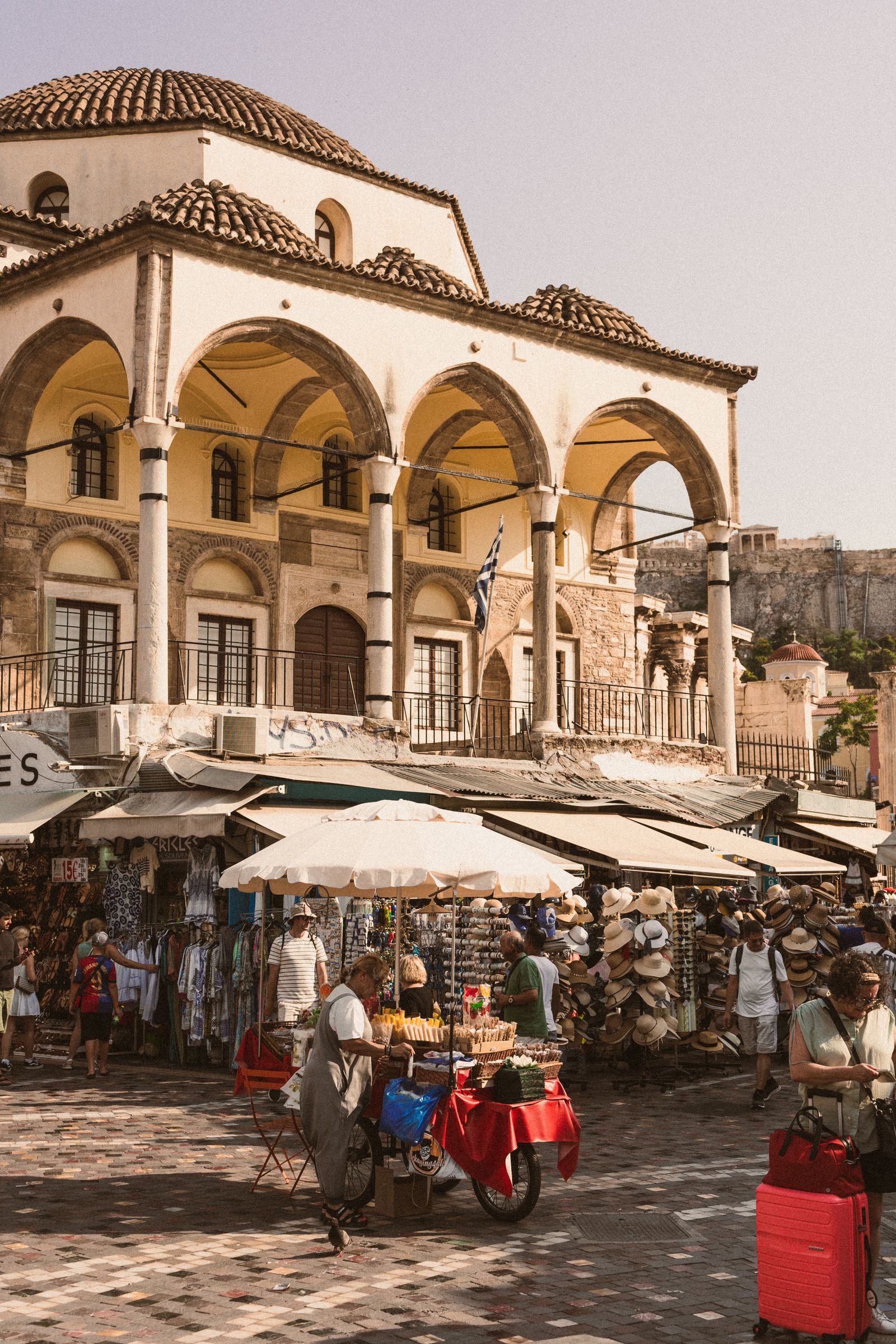 Cena cotidiana diante de edifício histórico em Atenas